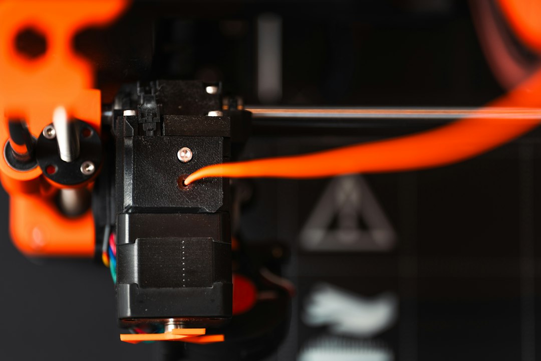 3d printer extruder machine orange filament from above
