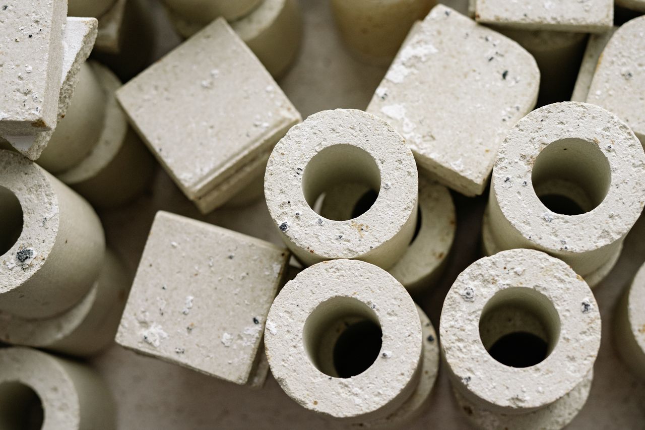 Abstract arrangement of cylindrical and square concrete shapes with a textured surface.