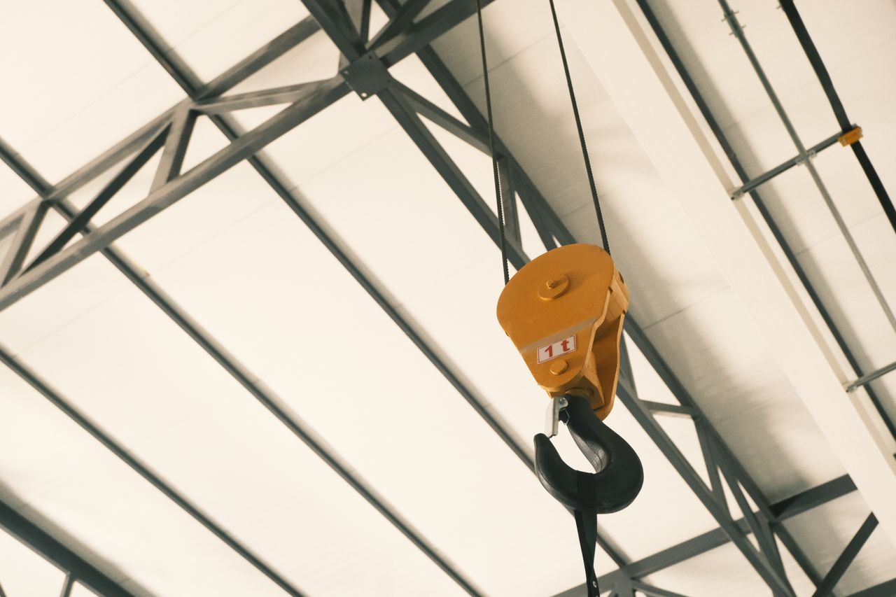Yellow crane hook in an industrial steel facility in Konya, Türkiye, highlighting heavy lifting equipment.